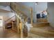 Lovely staircase with wood railing, carpeted steps, and natural light at 5371 Hazel Rd, Evergreen, CO 80439