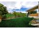 Expansive backyard featuring green grass, a covered patio and a wooden fence along the property line at 5238 S Jericho Way, Centennial, CO 80015