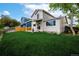 Spacious backyard with lush green grass, and a view of the home's exterior featuring a covered patio at 5238 S Jericho Way, Centennial, CO 80015