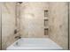 Renovated bathtub with shower features neutral tile at 5238 S Jericho Way, Centennial, CO 80015