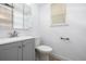 Cozy powder room features a stylish gray vanity, brushed nickel hardware, and white walls at 5238 S Jericho Way, Centennial, CO 80015