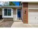 Charming front entrance, featuring a blue door, brick accents, and manicured landscaping at 5238 S Jericho Way, Centennial, CO 80015