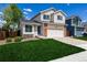 Two-story home with a bright blue door, attached garage, and a lush green lawn at 5238 S Jericho Way, Centennial, CO 80015