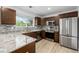 Modern kitchen features stainless steel appliances, stylish backsplash, and brown cabinets at 5238 S Jericho Way, Centennial, CO 80015
