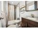 Modern bathroom with a stylish tiled shower, decorative shelves, and a dark wood vanity at 9325 Meade St, Westminster, CO 80031