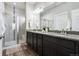 Bathroom featuring a double sink vanity with granite countertop, tile flooring, and glass enclosed shower at 98 Chipeta Way, Lochbuie, CO 80603