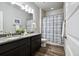 Bathroom featuring a double sink vanity with granite countertop and wood-style flooring at 98 Chipeta Way, Lochbuie, CO 80603