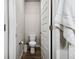 Powder room with wood-look flooring, toilet, and a white door with a towel hanging on it at 98 Chipeta Way, Lochbuie, CO 80603