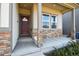 Front porch with stone accents and a red front door at 98 Chipeta Way, Lochbuie, CO 80603