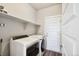 Functional laundry room with a washer, dryer, shelving, and a utility sink at 98 Chipeta Way, Lochbuie, CO 80603