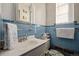 Small bathroom with blue tile, single sink vanity, and shower at 1475 Monaco Pkwy, Denver, CO 80220