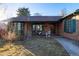 Brick home with green trim, porch, and mature trees at 1475 Monaco Pkwy, Denver, CO 80220