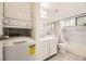 Bathroom with washer-dryer, marble tile, large mirror, updated vanity and shower-tub combination at 12368 W Nevada Pl # 206, Lakewood, CO 80228
