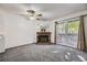 Cozy living room features a brick fireplace, ceiling fan, and sliding glass doors to a balcony at 12368 W Nevada Pl # 206, Lakewood, CO 80228