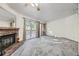 Living room featuring a brick fireplace and sliding doors leading to a balcony with a treed view at 12368 W Nevada Pl # 206, Lakewood, CO 80228
