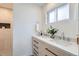 Well-lit bathroom featuring double sinks, wood drawers and a white countertop at 9455 W 37Th Ave, Wheat Ridge, CO 80033