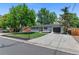 Charming single-story home featuring a white brick exterior, lush green lawn, and attached garage in a desirable neighborhood at 9455 W 37Th Ave, Wheat Ridge, CO 80033