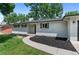 Charming single-story home featuring a white brick exterior, lush green lawn, and walkway to entry at 9455 W 37Th Ave, Wheat Ridge, CO 80033