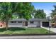 Charming single-story home featuring a white brick exterior, lush green lawn, and attached garage in a desirable neighborhood at 9455 W 37Th Ave, Wheat Ridge, CO 80033
