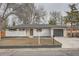 Charming single-story home featuring a white brick exterior, well-manicured lawn, and attached garage at 9455 W 37Th Ave, Wheat Ridge, CO 80033