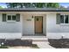 Close up on modern white brick house with black mulch, white address numbers, and stained front door at 9455 W 37Th Ave, Wheat Ridge, CO 80033