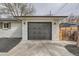Close up of the painted white brick, single story home's grey garage doors at 9455 W 37Th Ave, Wheat Ridge, CO 80033