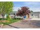 Charming single-story home with a well-manicured lawn and gravel driveway leading to the attached garage at 6245 W 53Rd Ave, Arvada, CO 80002
