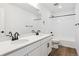 Bathroom featuring double sinks, white cabinets, black hardware, and a shower-tub combination at 8346 Cokedale Cir, Littleton, CO 80125