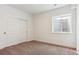 Cozy bedroom with soft carpet, window well, and a closet with sliding doors at 8346 Cokedale Cir, Littleton, CO 80125