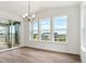 Bright dining area with modern light fixture, large windows, and sliding glass doors leading to an outdoor space at 8346 Cokedale Cir, Littleton, CO 80125