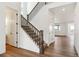 Bright entryway featuring hardwood floors, a staircase with dark wood railings, and white walls at 8346 Cokedale Cir, Littleton, CO 80125