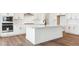 Modern kitchen features white cabinets, stainless steel appliances, a spacious island with a sink and quartz countertops at 8346 Cokedale Cir, Littleton, CO 80125