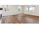 Open-concept living area with hardwood floors, white walls, fireplace, and abundant natural light from large windows at 8346 Cokedale Cir, Littleton, CO 80125