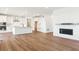 Open-concept living area featuring hardwood floors, a modern kitchen, and a cozy fireplace at 8346 Cokedale Cir, Littleton, CO 80125