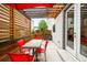 Outdoor patio with modern table, red chairs, and an overhead wood trellis with shade at 3727 Tejon St, Denver, CO 80211