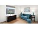 Bright sitting room featuring a blue tufted sofa and large window at 3727 Tejon St, Denver, CO 80211