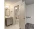 Bathroom with vanity and opened door with bath and shower featuring marble surround at 1820 Newland Ct # 213, Lakewood, CO 80214