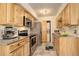 This modern kitchen has stainless steel appliances, light wood cabinets, stone backsplash, and a convenient laundry closet at 1820 Newland Ct # 213, Lakewood, CO 80214