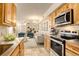 Bright kitchen features stainless steel appliances, light wood cabinets, and flows into the adjacent living area at 1820 Newland Ct # 213, Lakewood, CO 80214