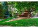 Sprawling backyard with a spacious deck nestled among mature trees and lush landscaping at 2245 Ridgeview Way, Longmont, CO 80504
