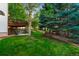 Well-manicured backyard with lush green grass and mature trees, creating a serene outdoor space at 2245 Ridgeview Way, Longmont, CO 80504