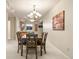 A well-lit dining area featuring a wooden table, chandelier, and view of the kitchen at 2245 Ridgeview Way, Longmont, CO 80504
