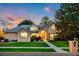 Charming two-story brick home featuring a well-manicured lawn, mature trees, and inviting entrance at sunset at 2245 Ridgeview Way, Longmont, CO 80504