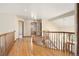 Sun-filled hallway boasts hardwood floors and railing overlooking the foyer and front door at 2245 Ridgeview Way, Longmont, CO 80504