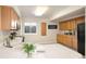 Cozy kitchen with wooden cabinets, a bright window, and sleek black appliances providing modern convenience at 2245 Ridgeview Way, Longmont, CO 80504