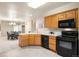 Open kitchen boasts ample cabinet space, black appliances, and a view into the adjacent dining area at 2245 Ridgeview Way, Longmont, CO 80504