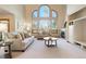Spacious living room with high ceilings, large arched windows, fireplace, and comfortable seating area, creating a cozy ambiance at 2245 Ridgeview Way, Longmont, CO 80504
