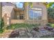 Back exterior of home with tan siding, stone accents, and a covered porch at 14333 E Napa Pl # 5D, Aurora, CO 80014