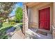 Charming entrance with a vibrant red door and stone pillar at 14333 E Napa Pl # 5D, Aurora, CO 80014