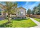 Landscaped front yard with lush green grass, mature trees, and inviting walkway at 14333 E Napa Pl # 5D, Aurora, CO 80014